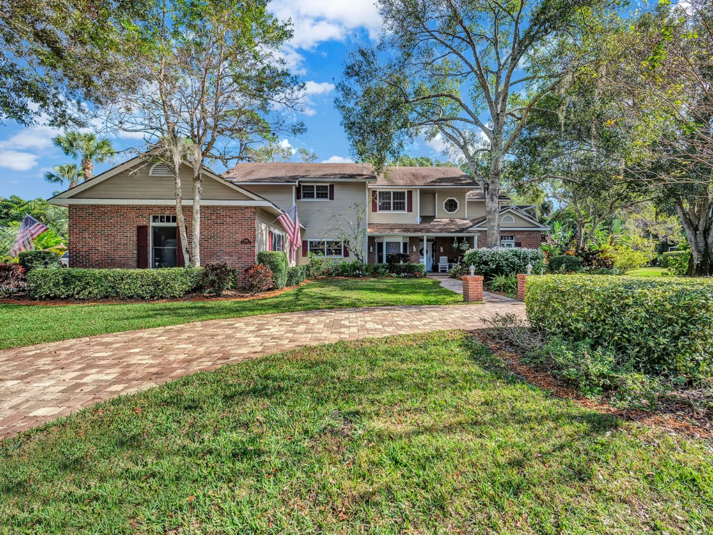 a front view of a house with a yard and trees