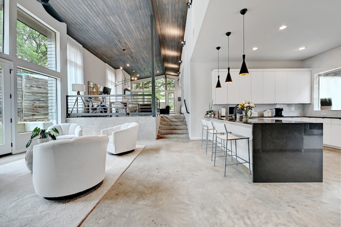 a living room with couches and kitchen view with wooden floor