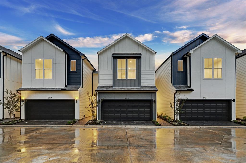 a front view of a house with yard and parking