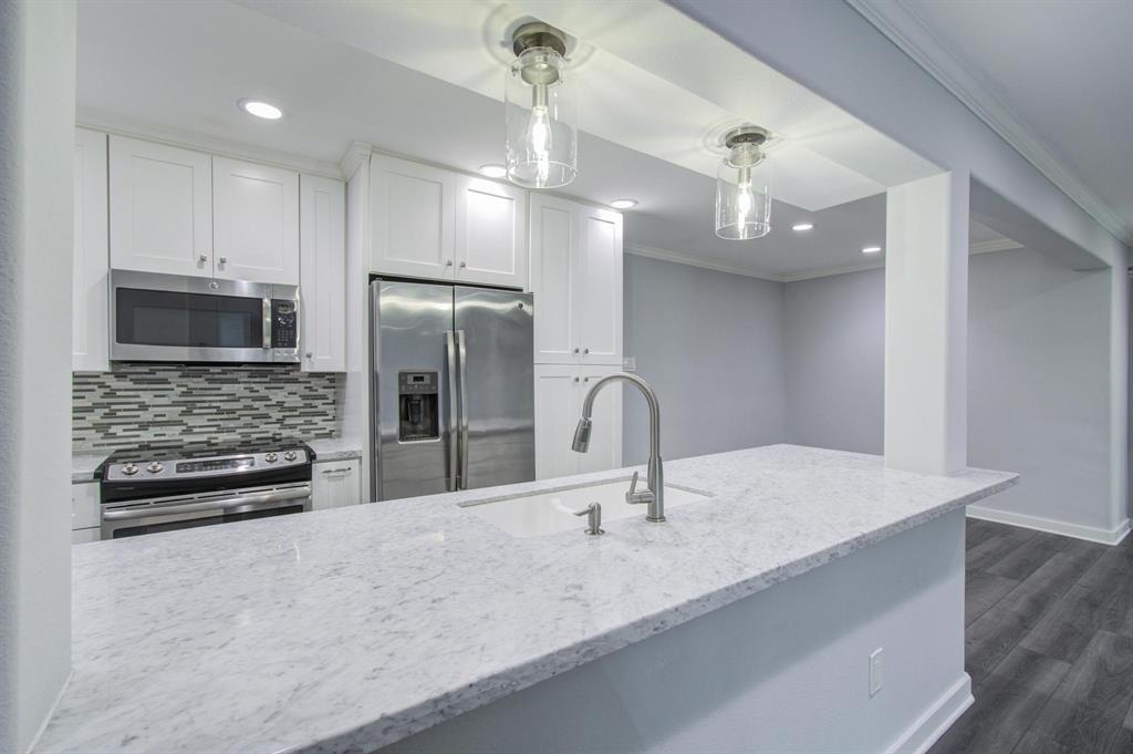 a kitchen with stainless steel appliances a sink and a refrigerator