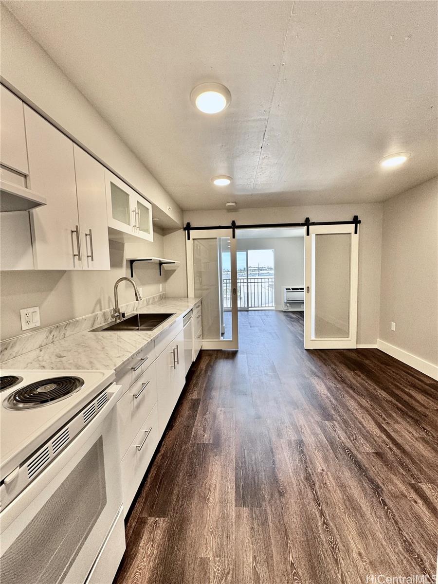 a large kitchen with a lot of counter space and wooden floor