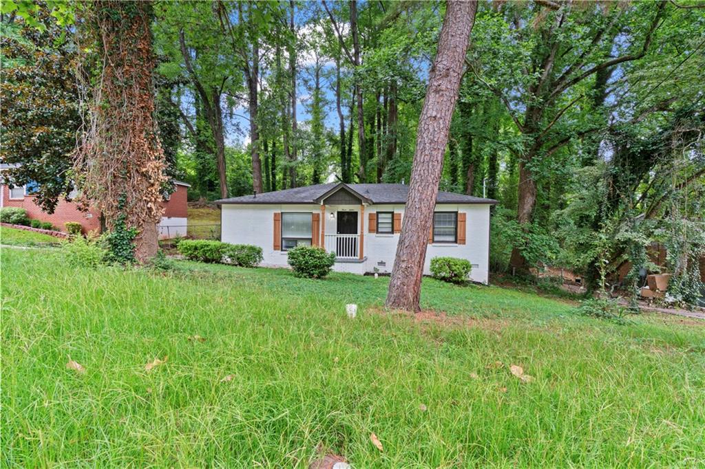 a front view of a house with a yard and trees