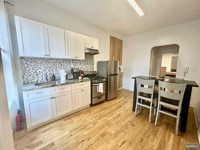 a kitchen with a sink cabinets and wooden floor