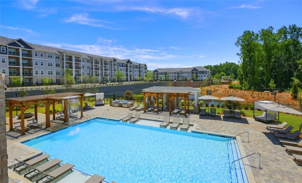 a view of a swimming pool with a patio and a yard