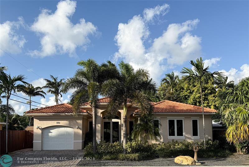 a view of a house with a yard and potted plants