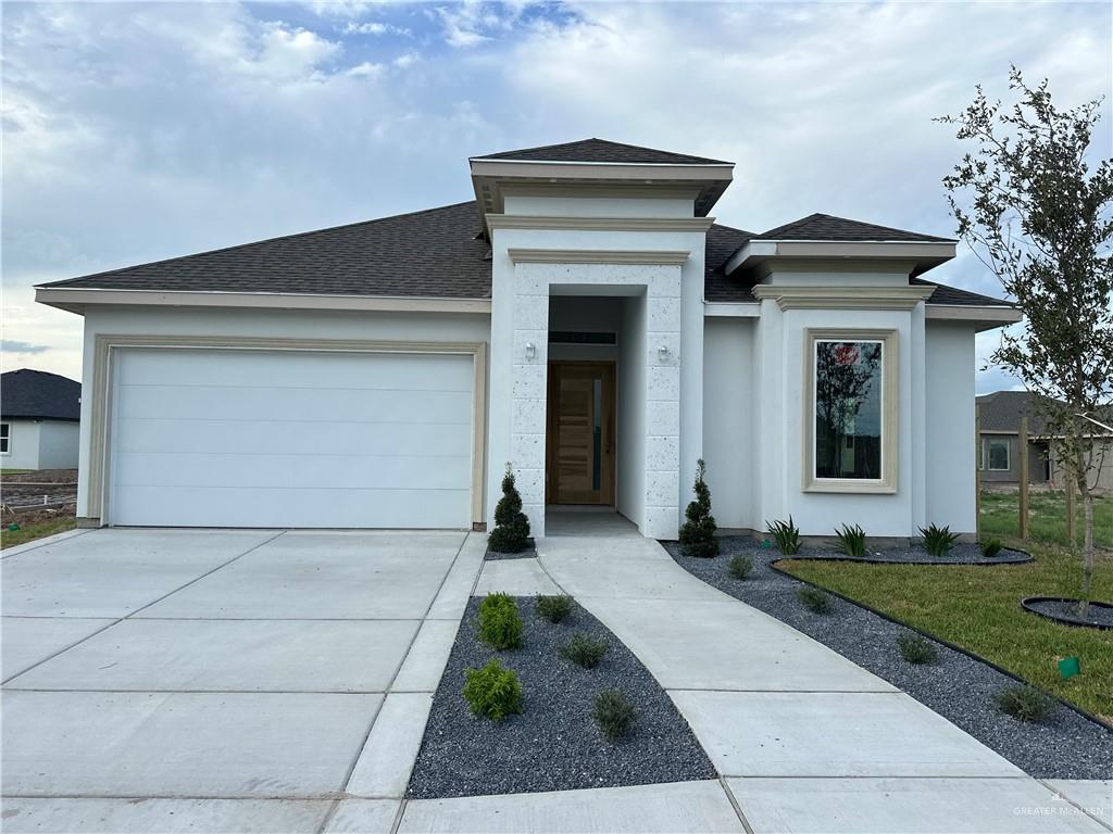 Prairie-style home with a garage and a front lawn