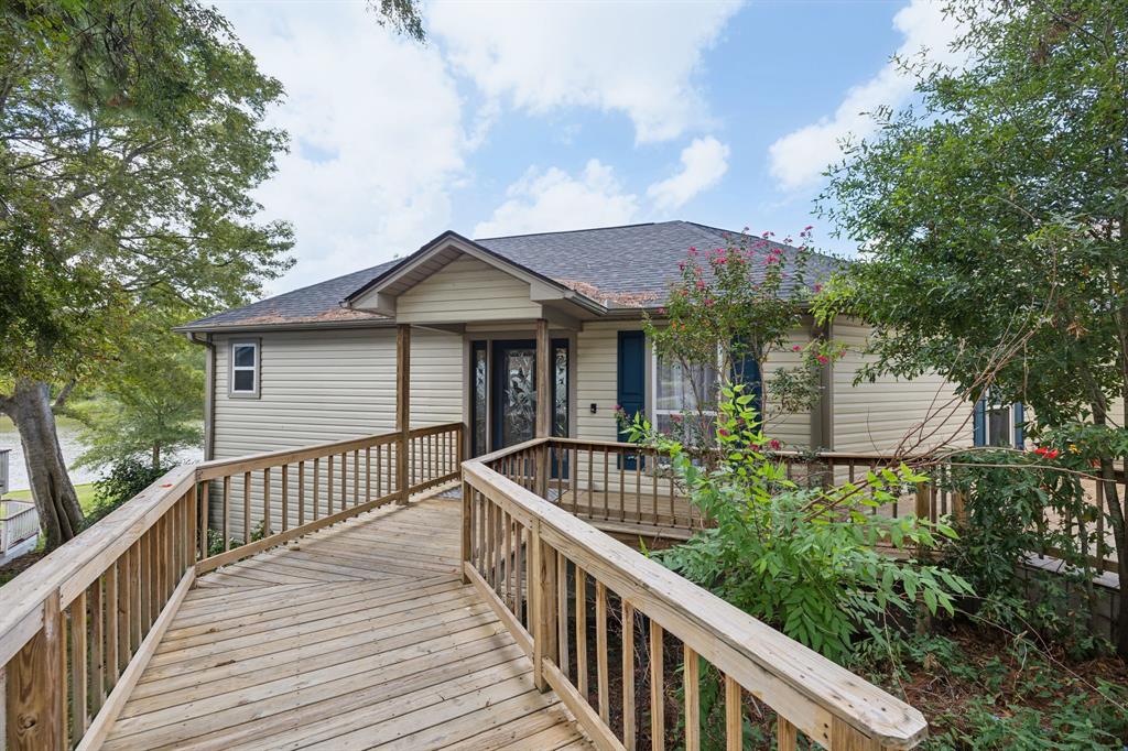 a view of house with wooden deck and furniture