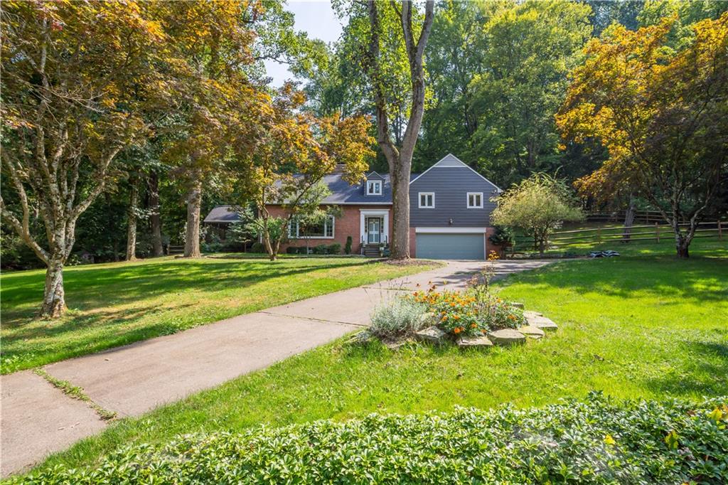 a front view of a house with a yard and trees