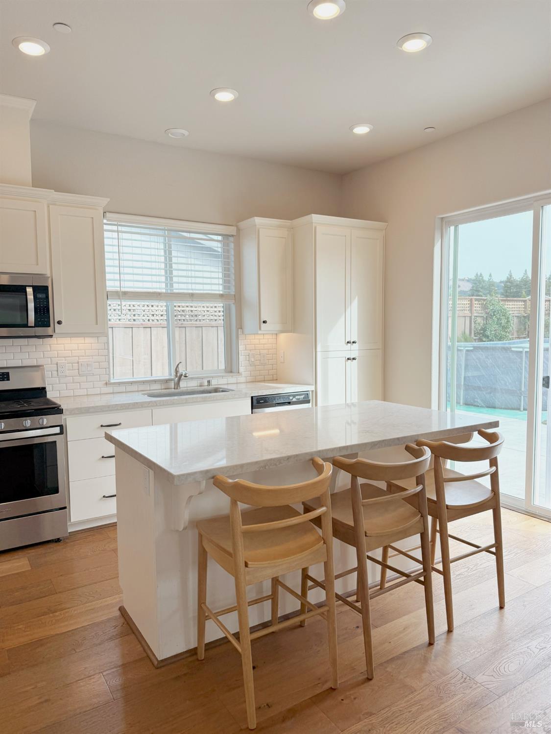 a kitchen with granite countertop white cabinets and stainless steel appliances