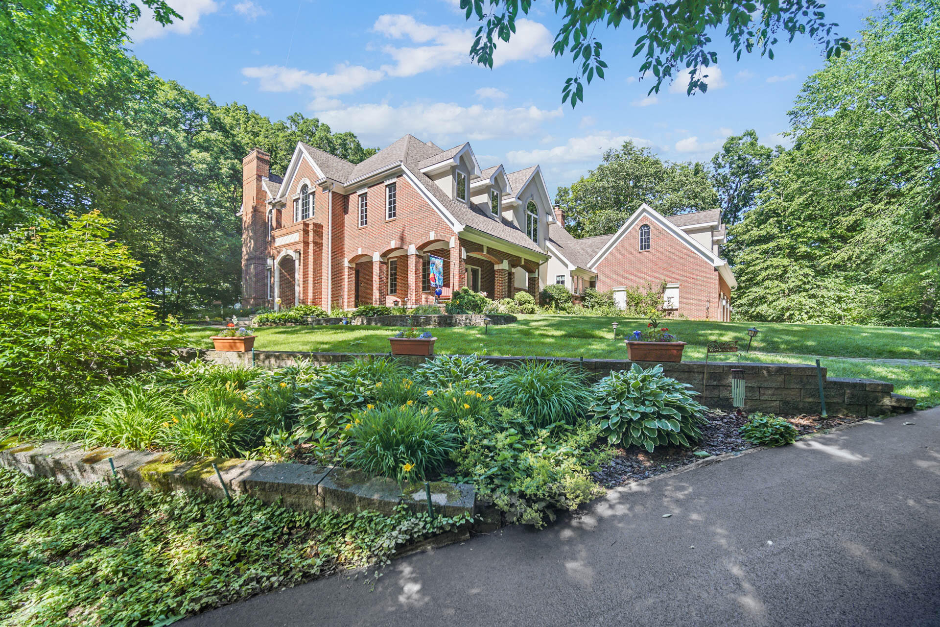 a front view of a house with a yard and potted plants