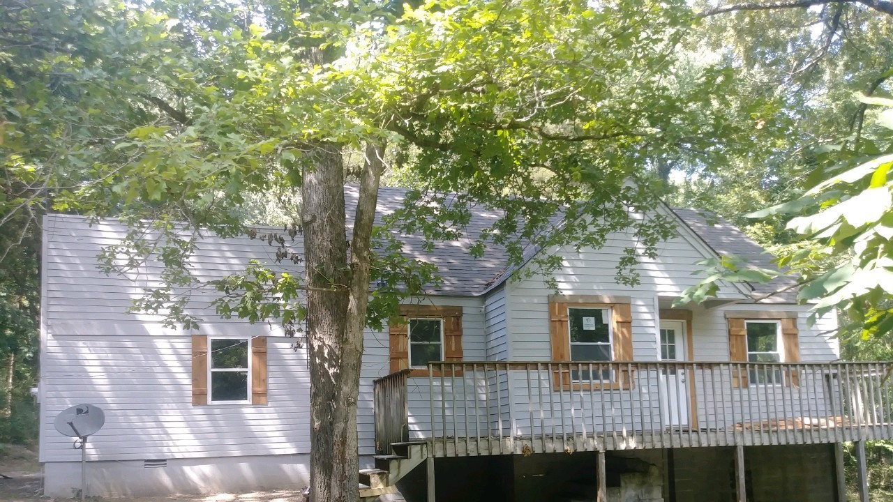 a front view of a house with a tree