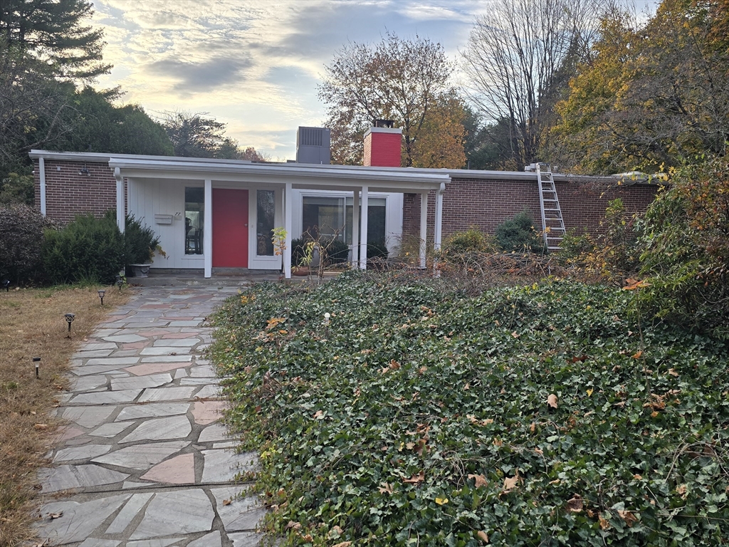 a front view of house with yard and trees around