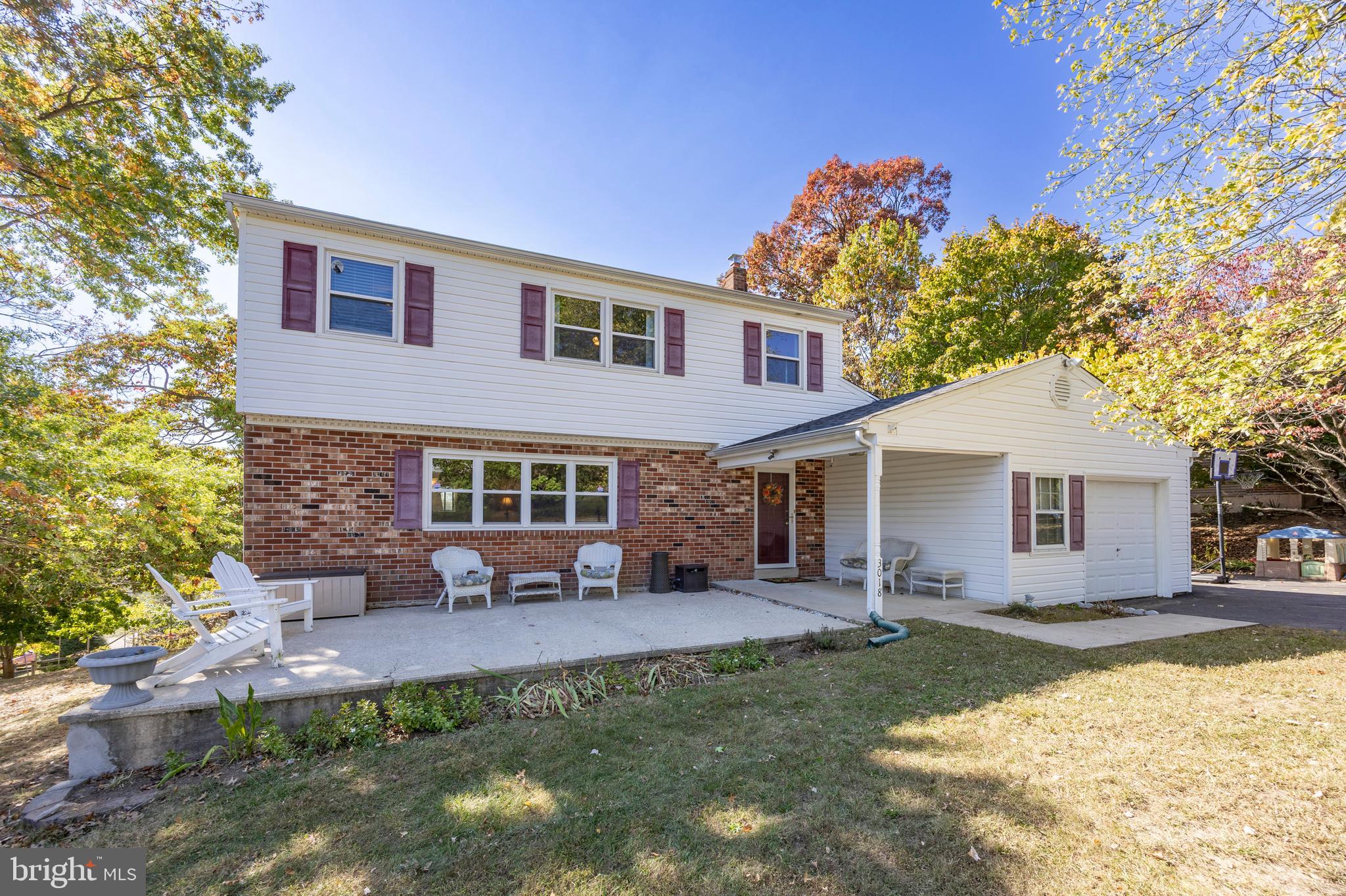 a front view of house with yard and trees in the background