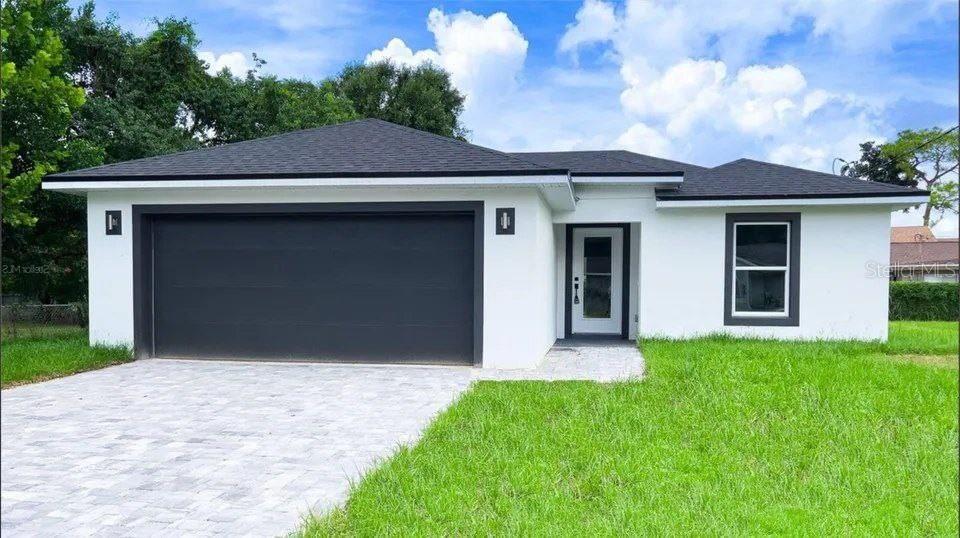 a front view of a house with a yard and garage