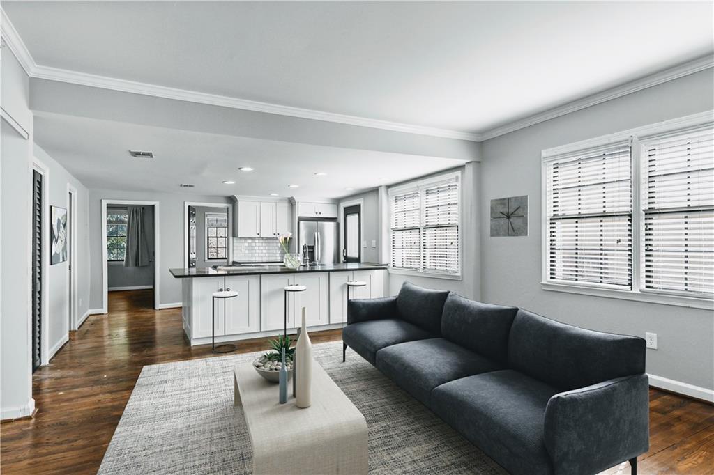 a living room with stainless steel appliances granite countertop furniture and a couch