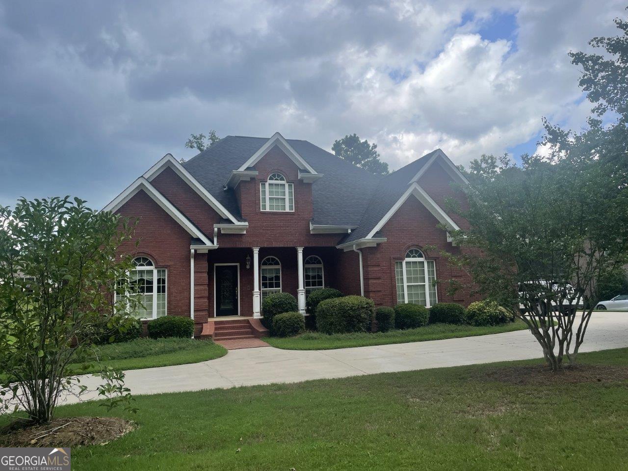 a front view of a house with a garden