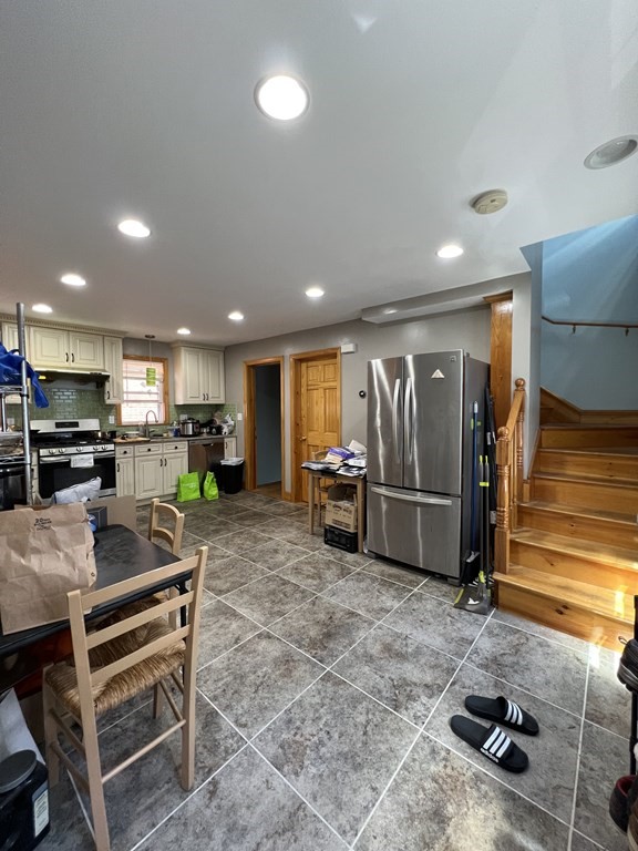 a kitchen with refrigerator and chairs