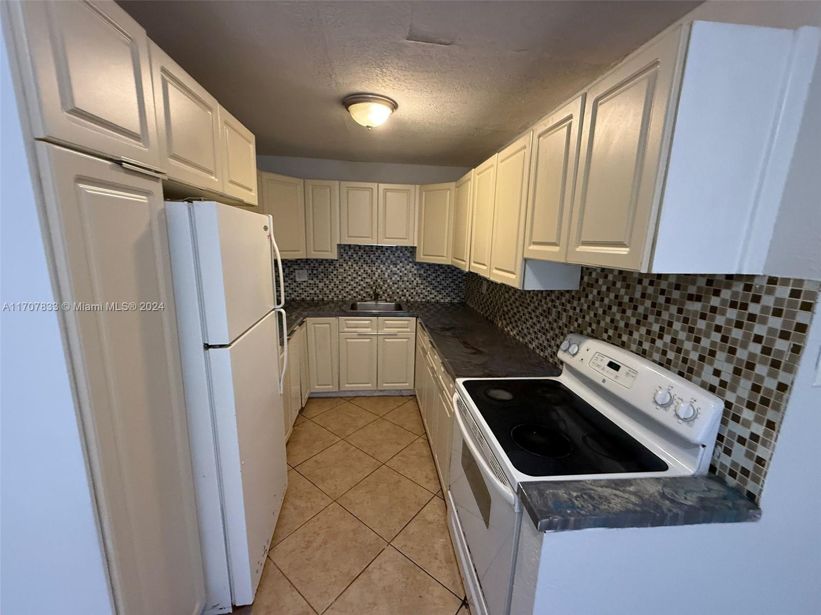 a kitchen with a refrigerator a stove a sink and a window