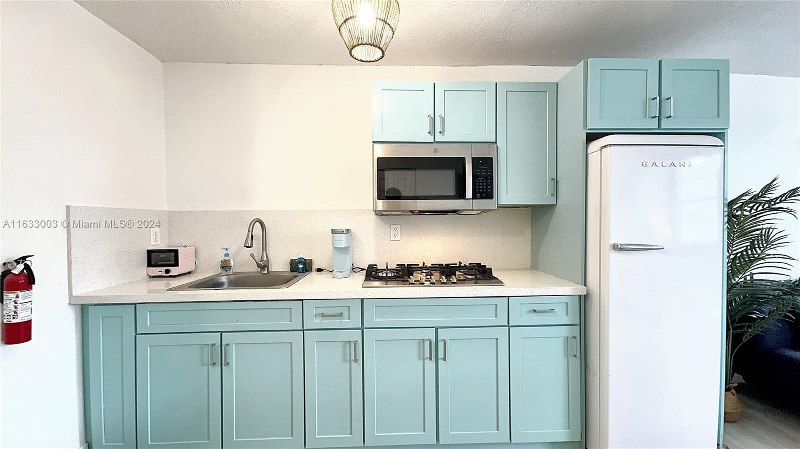 a kitchen with stainless steel appliances granite countertop a sink stove top oven and refrigerator