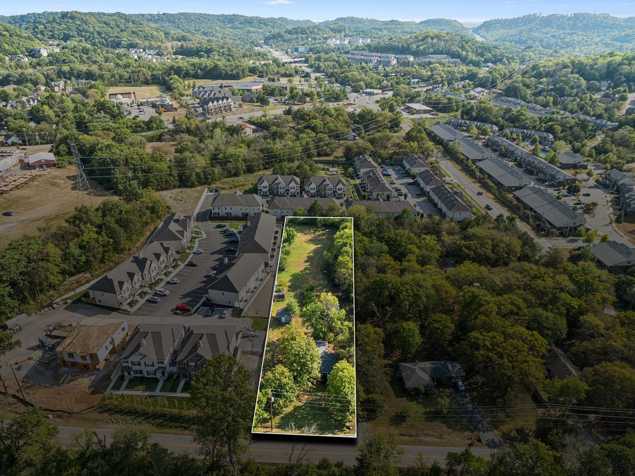 an aerial view of a residential houses covered in trees