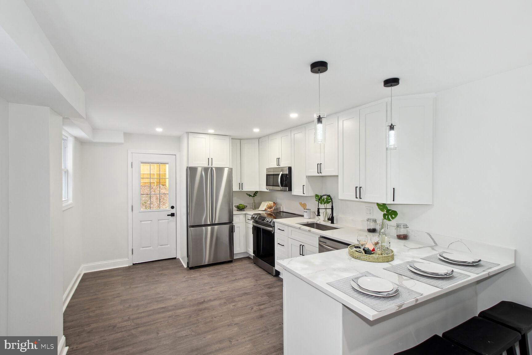 a kitchen with stainless steel appliances granite countertop a sink refrigerator and cabinets