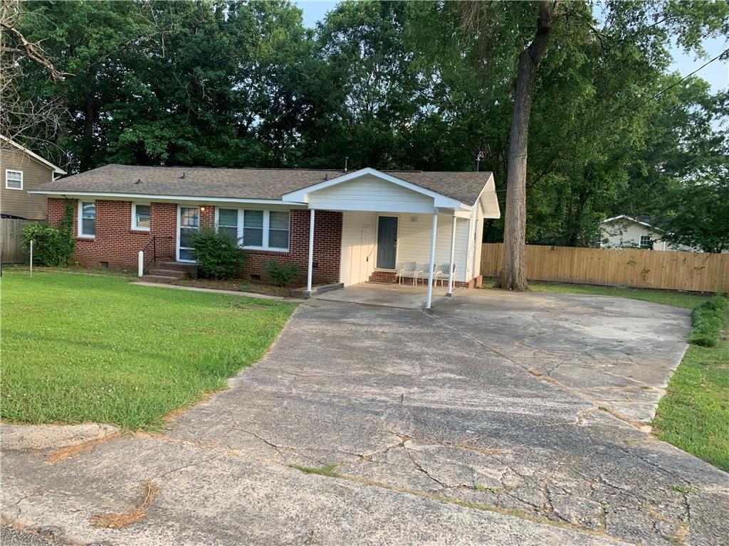 a front view of a house with a yard and trees