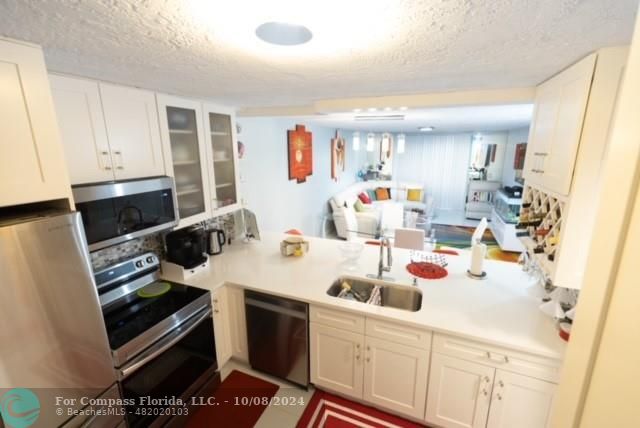 a kitchen with a sink a stove and cabinets