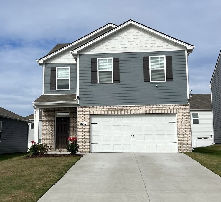 a front view of a house with a yard and garage