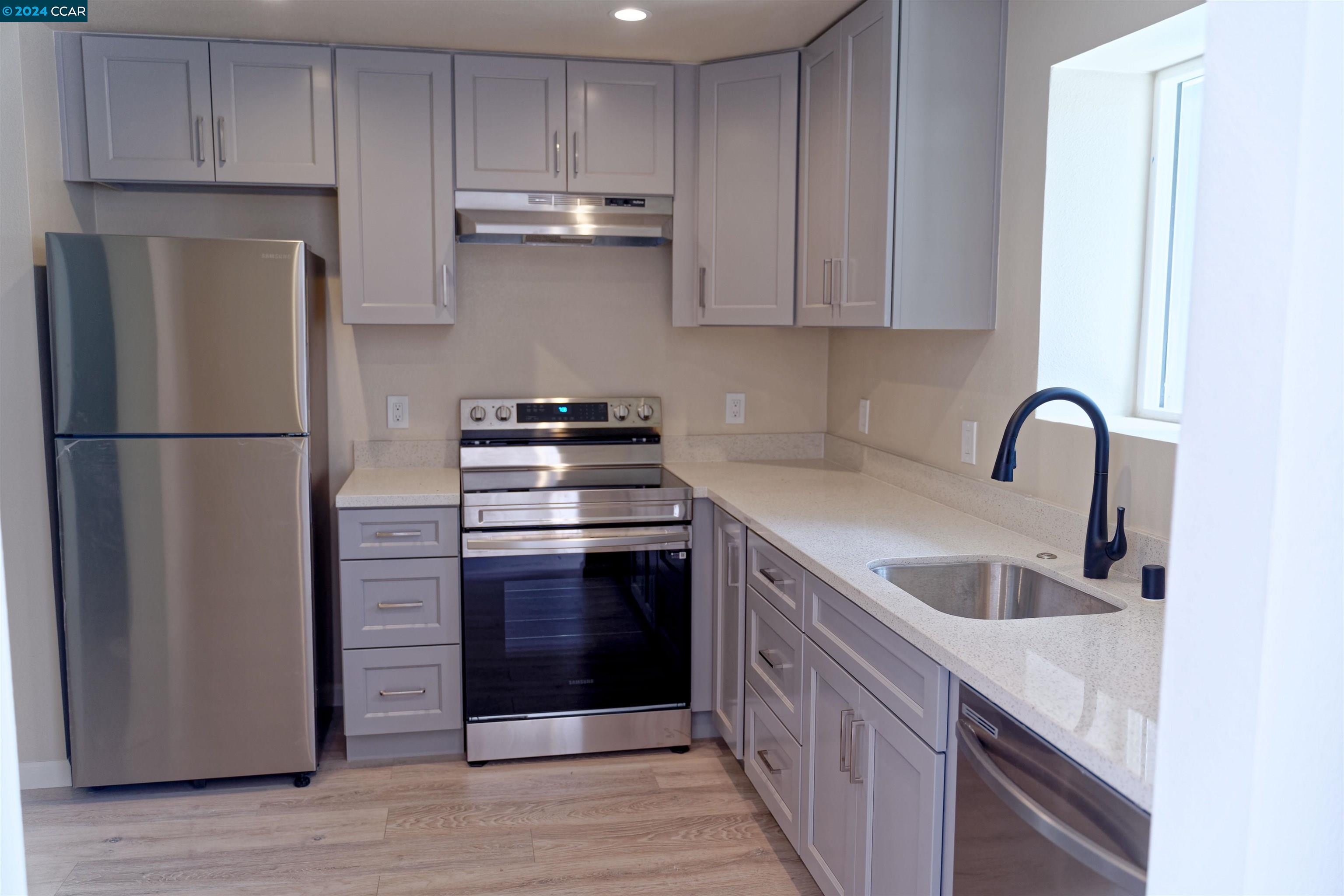 a kitchen with stainless steel appliances granite countertop a refrigerator sink and cabinets