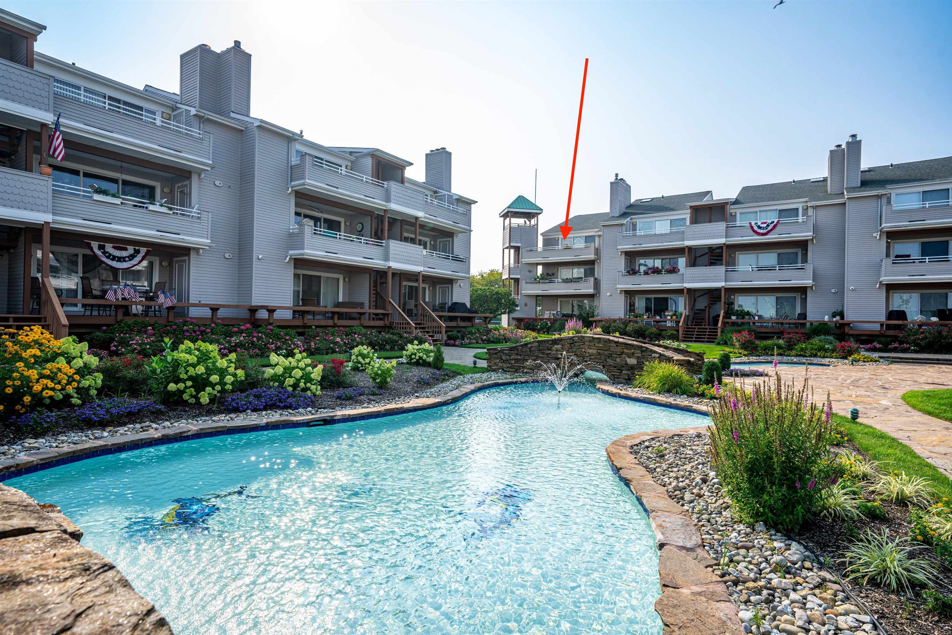 a view of a house with swimming pool lawn chairs and a yard