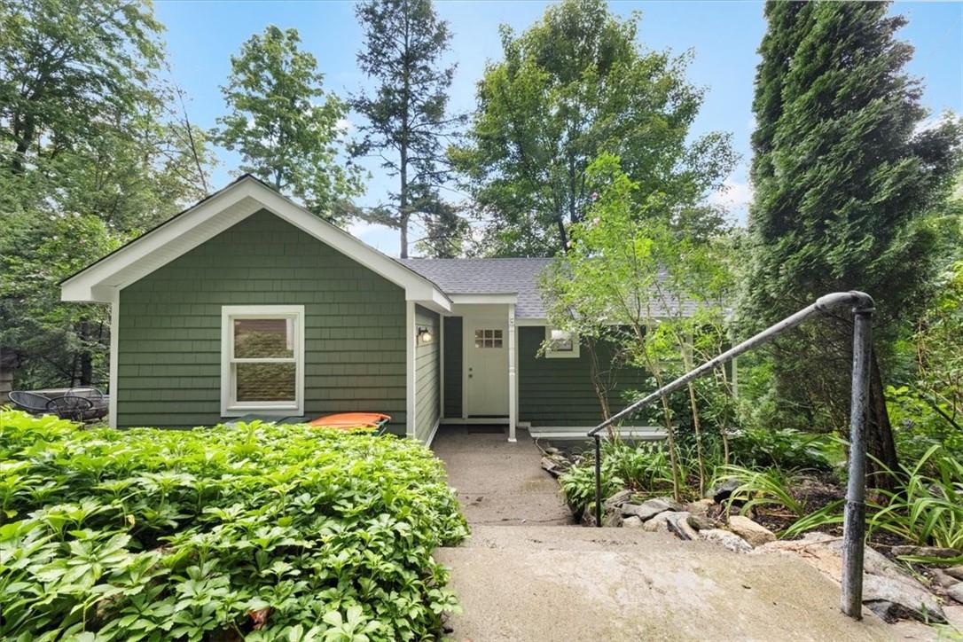 a house with a small yard plants and large trees