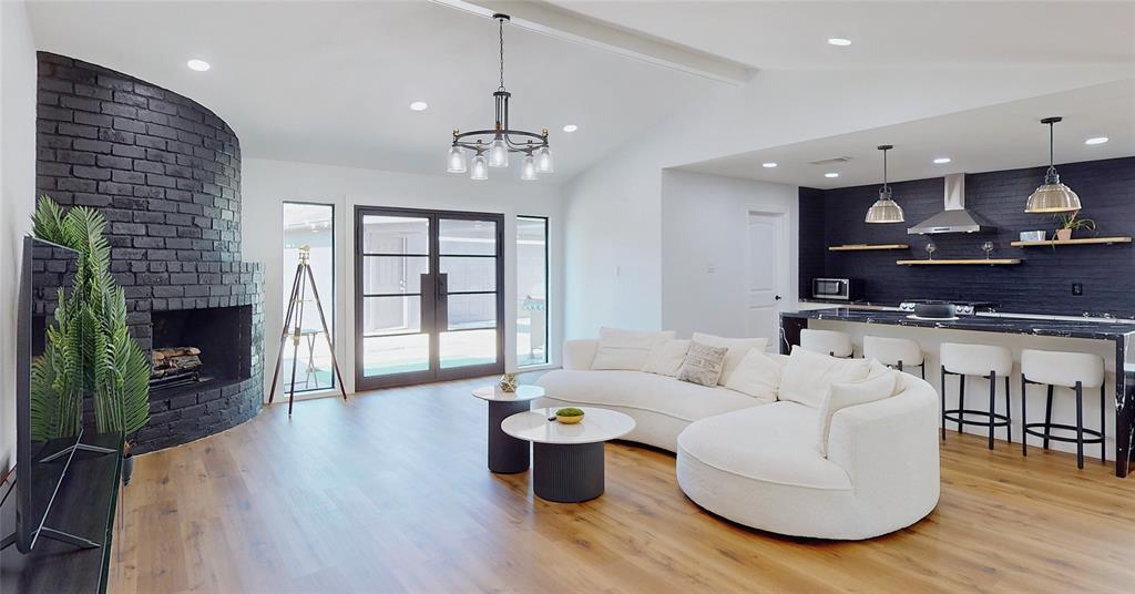 a living room with furniture a wooden floor and a fireplace