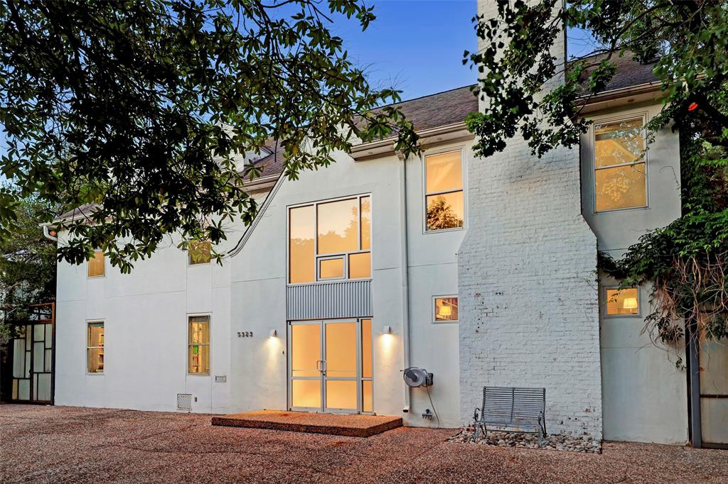 An extra-wide circular driveway welcomes guests to 5323 Cherokee, where a white stucco façade and dormer windows make a charming first impression. Throughout the property, tall mature trees add shade and privacy.