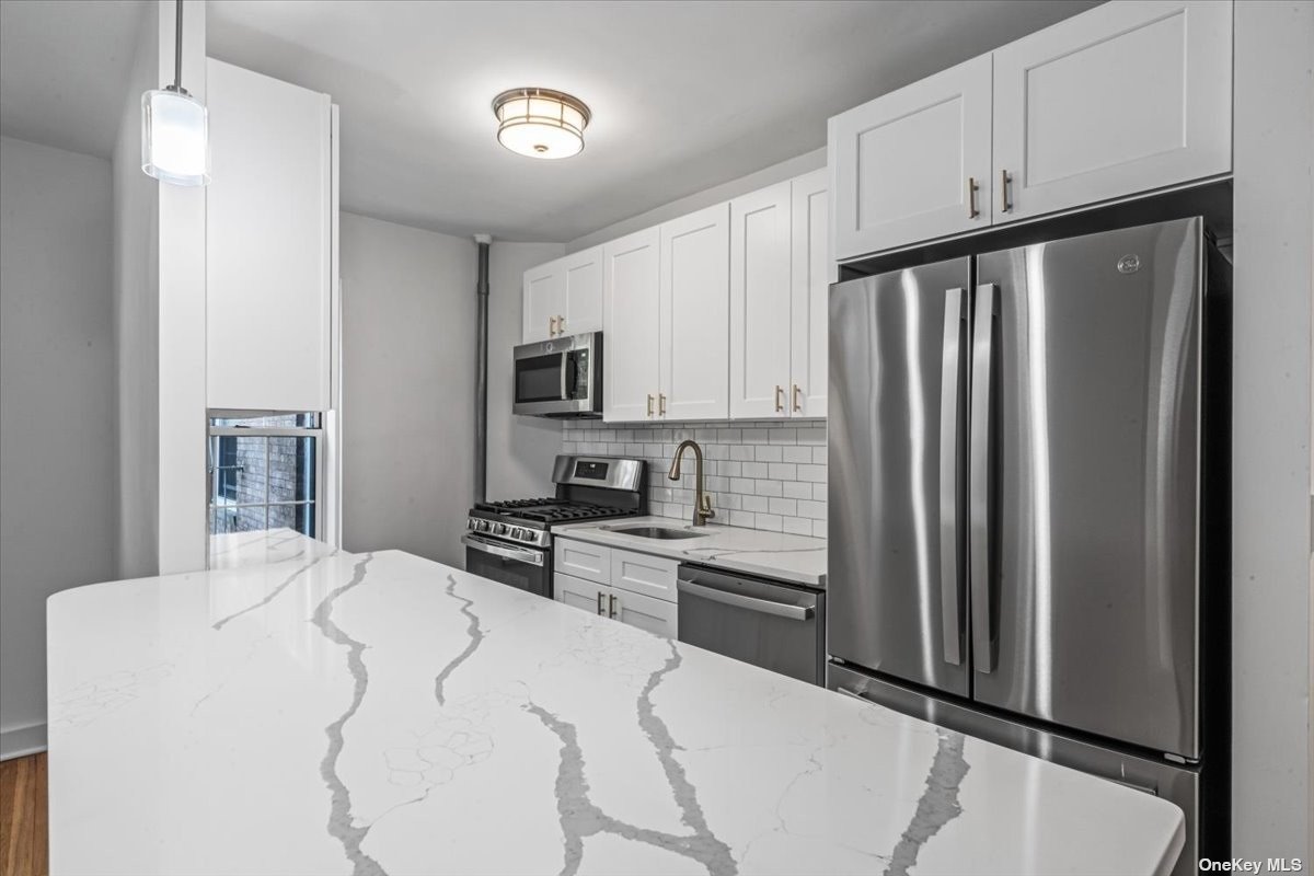 a kitchen with stainless steel appliances a refrigerator sink and microwave