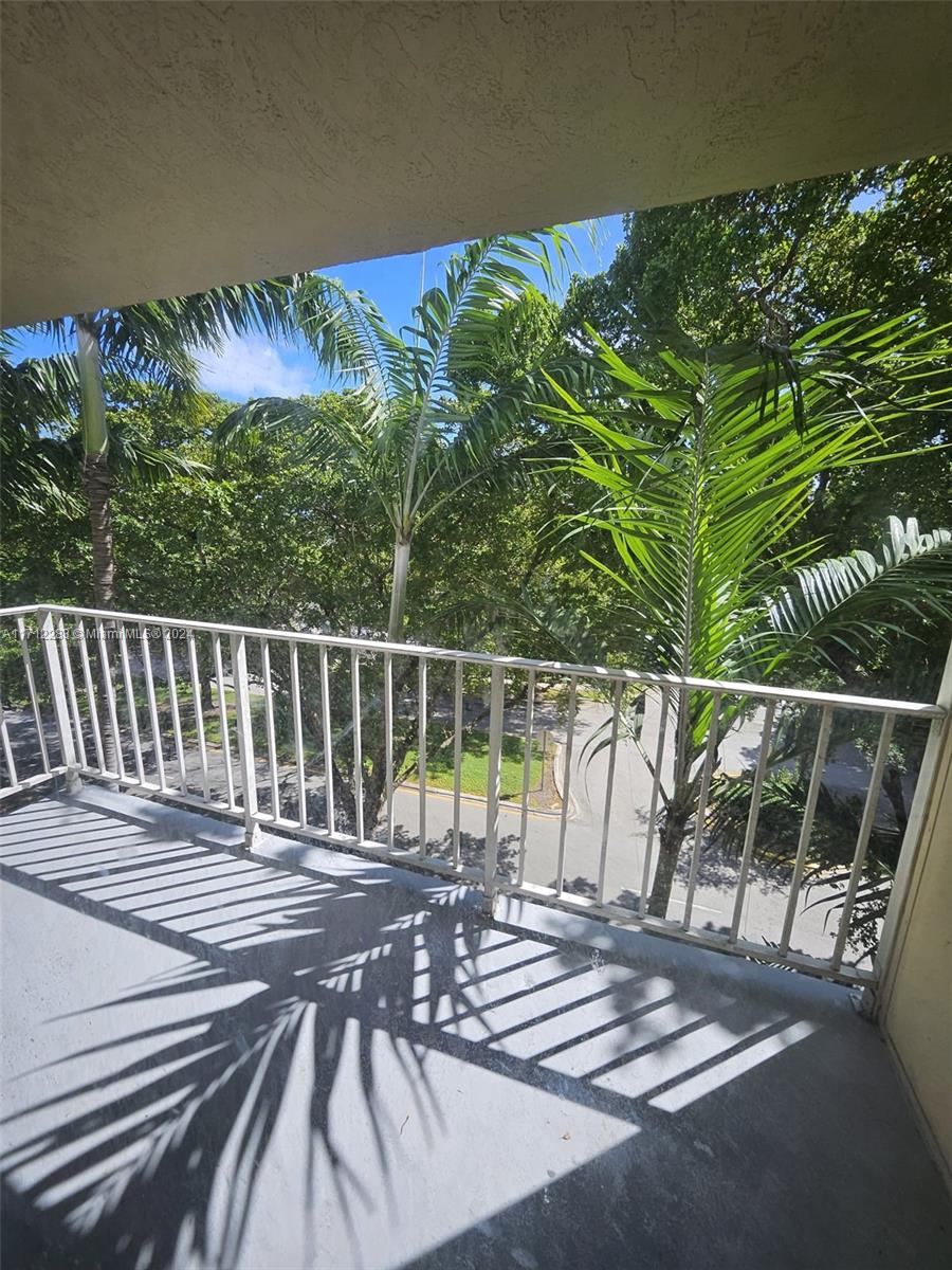 a view of balcony with wooden floor and fence