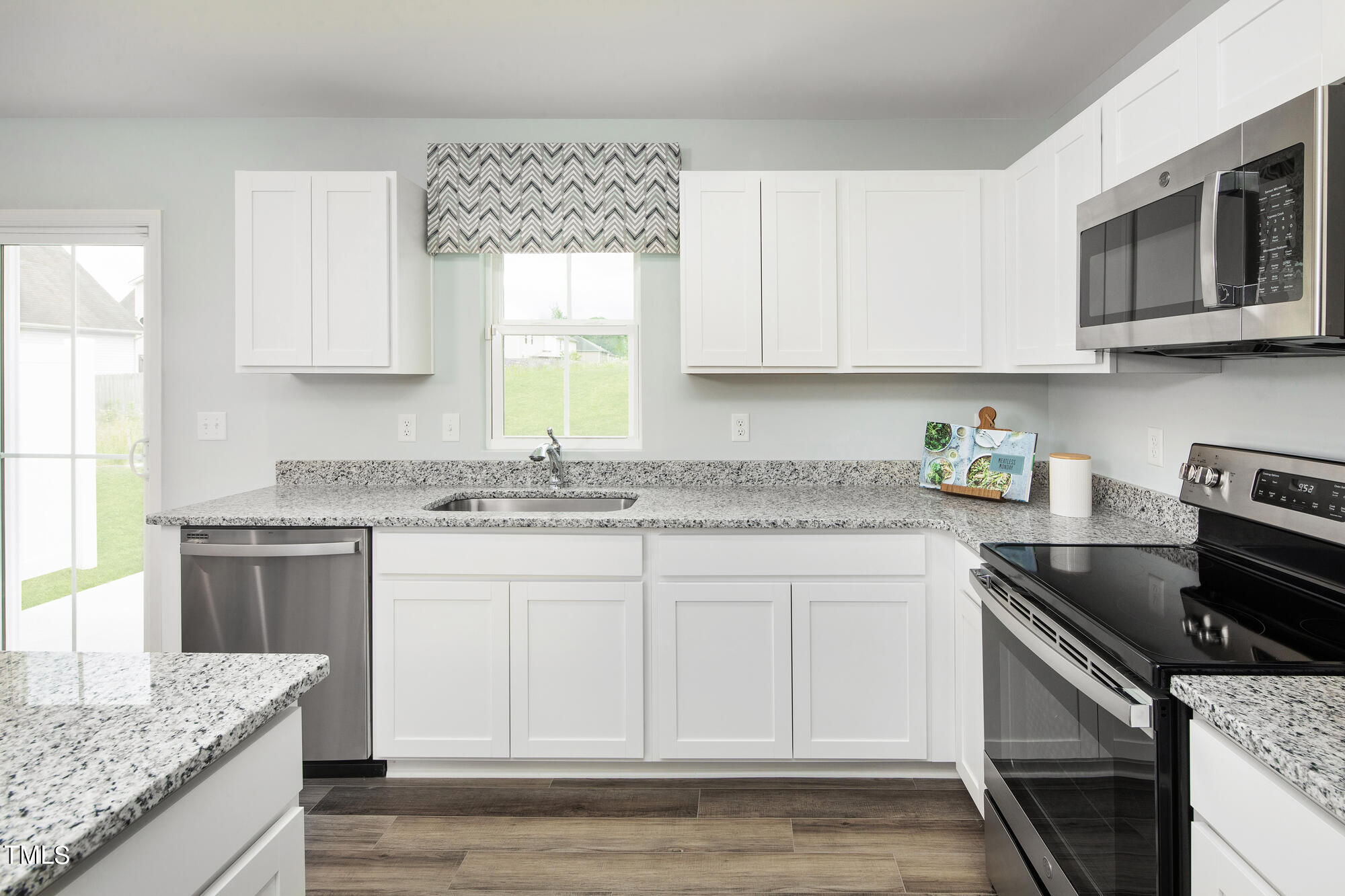 a kitchen with granite countertop a sink stove and cabinets