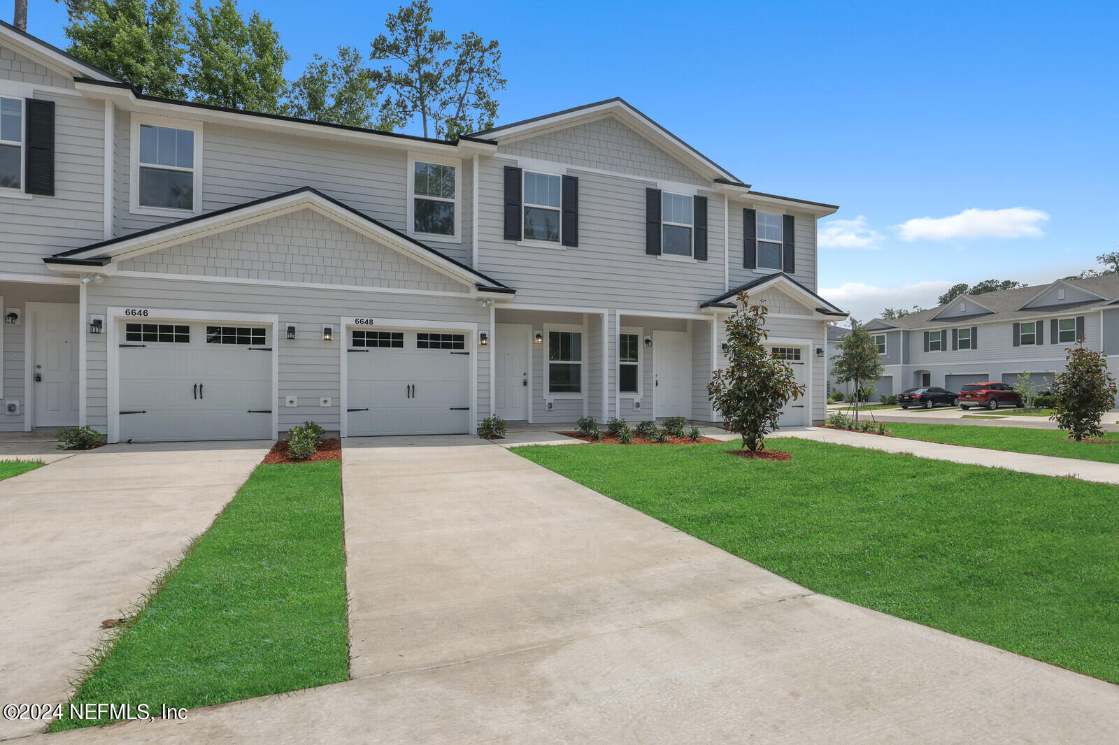 a view of a big house with a big yard and large trees