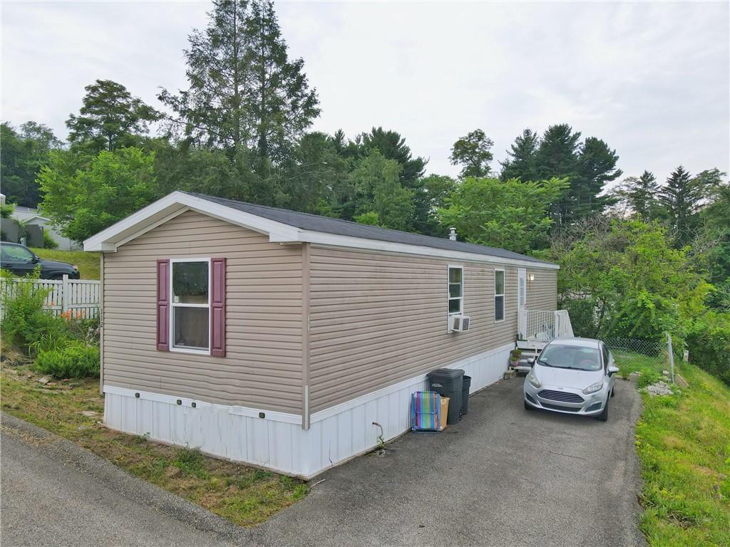 a view of a house with a backyard and trees