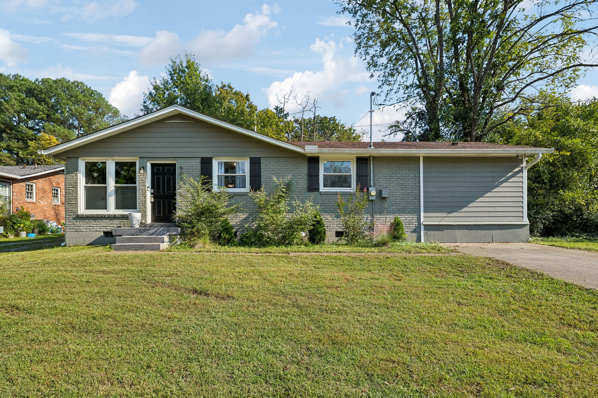 a front view of house with yard and trees around