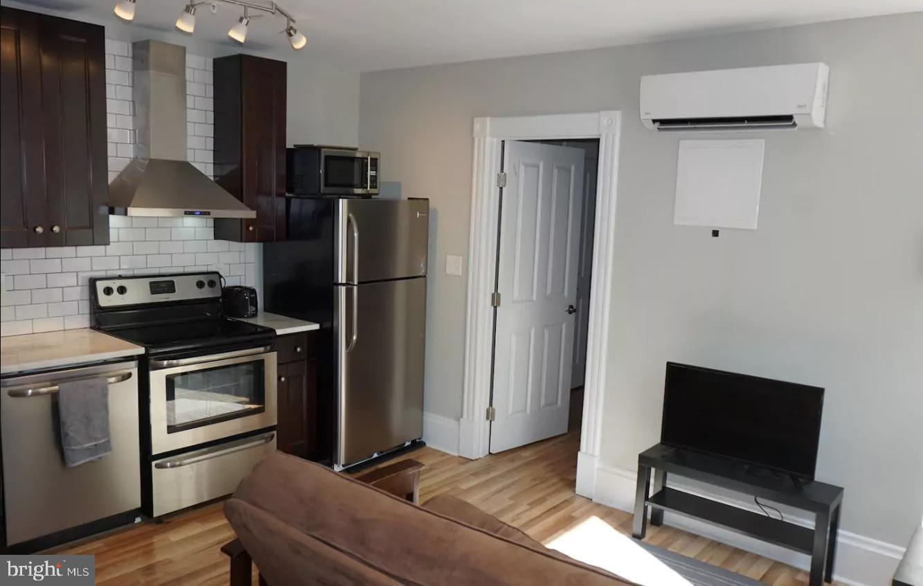 a kitchen with a refrigerator and a stove top oven