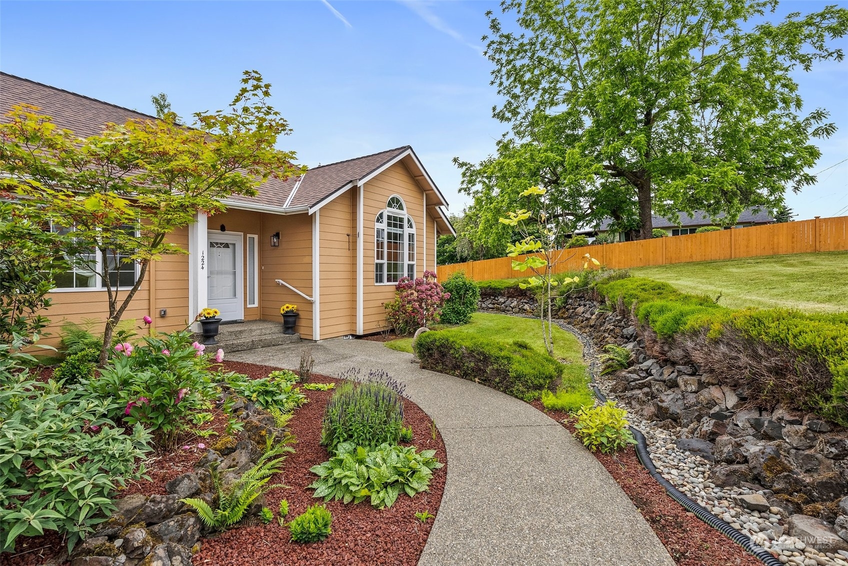 a view of a house with a yard and potted plants