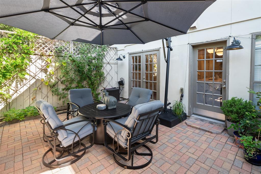 a view of a patio with table and chairs under an umbrella