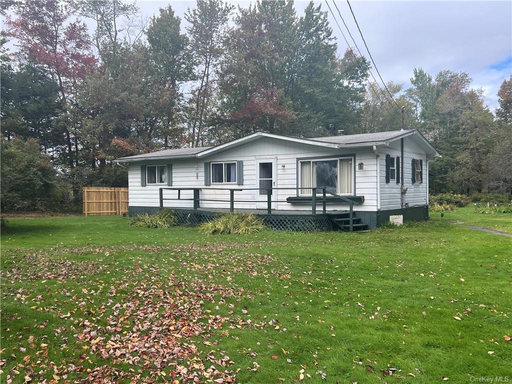 a front view of a house with a garden and trees