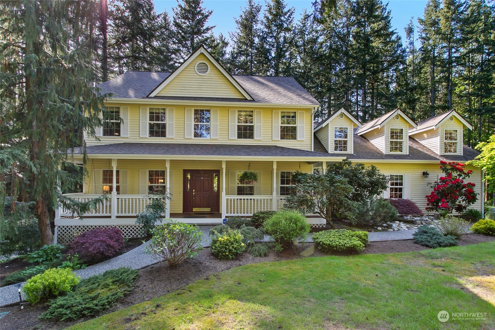 a front view of a house with a yard and trees