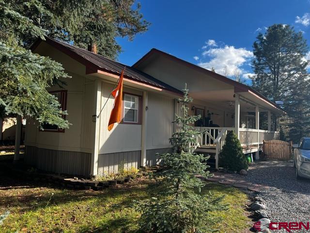 a front view of house with yard and trees in the background