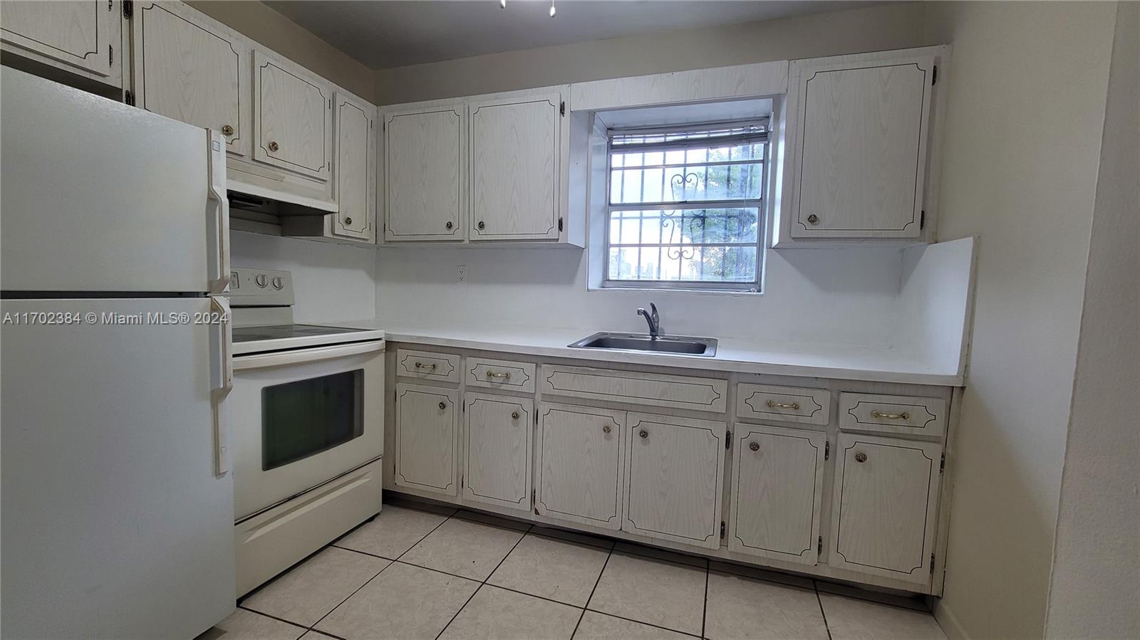 a kitchen with granite countertop white cabinets white stainless steel appliances and sink