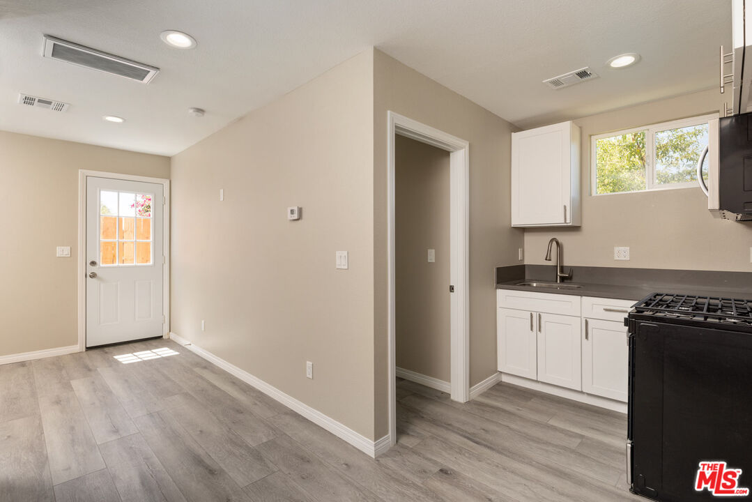 a view of a kitchen cabinets a sink and a wooden floor