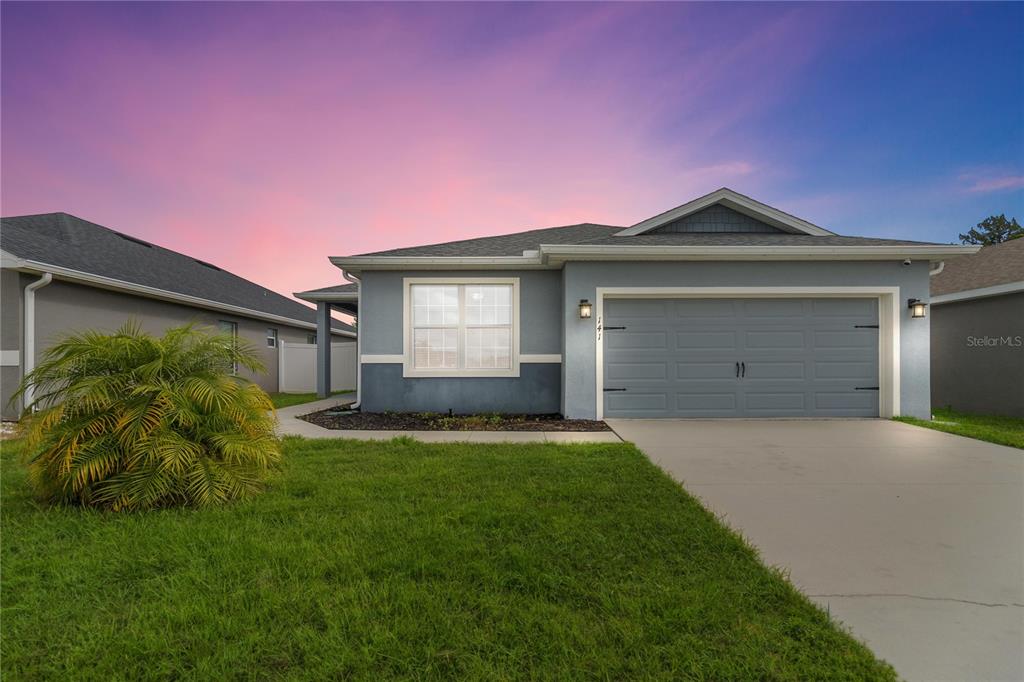 a front view of a house with a yard and garage