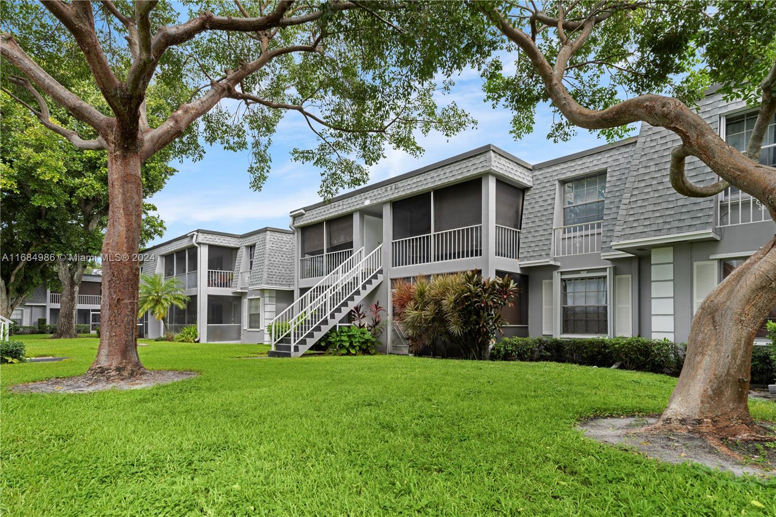 a front view of a house with a yard and trees