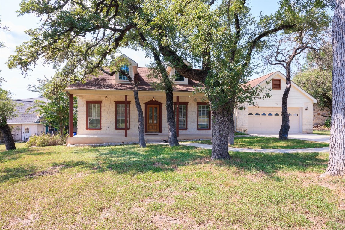 a view of a house with a yard and large tree